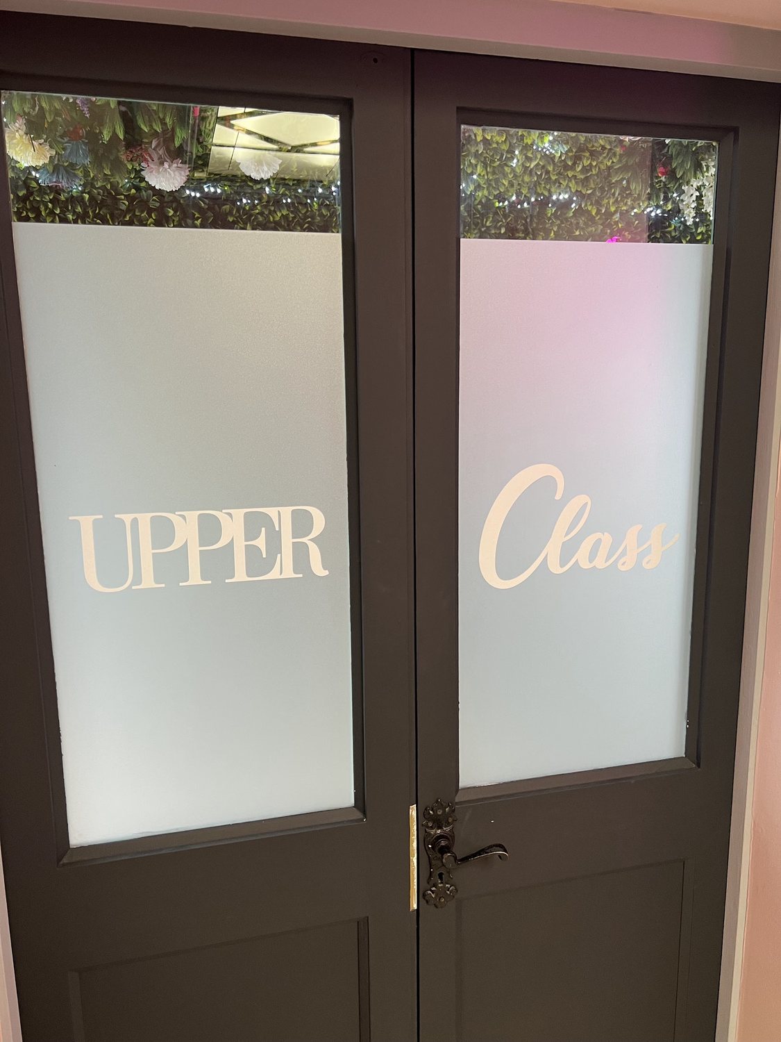 The black double doors with Upper Class in frosted lettering