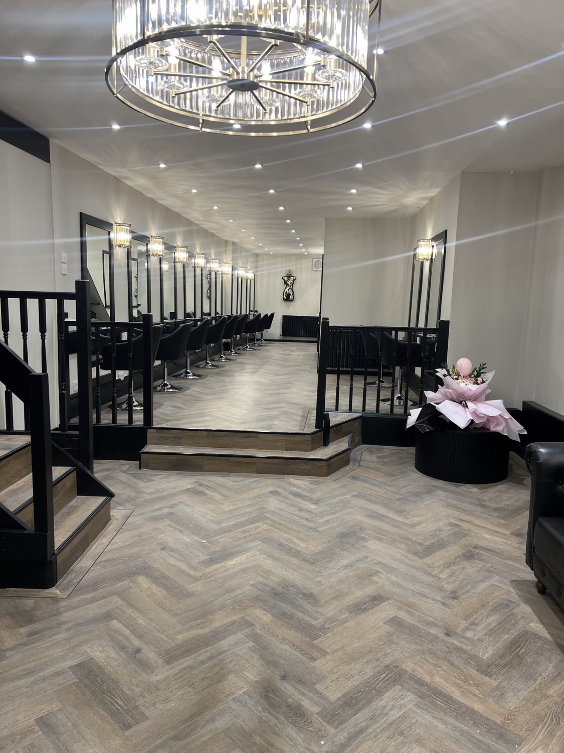 The salon floor under a crystal chandelier, with a herringbone floor
